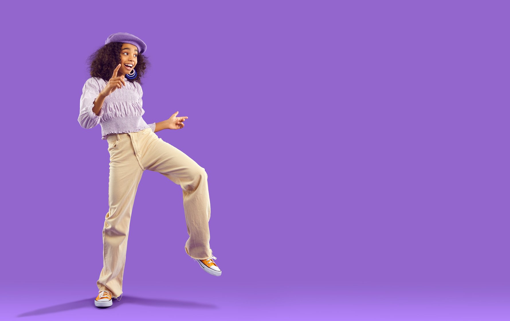 Smiling Teen Girl Dancing on Violet Background